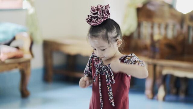 Little cute child kid baby girl 3-4 years old wearing light clothes dancing