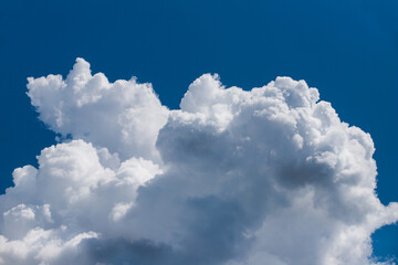 Naklejka na ściany i meble Large white cumulus cloud and deep blue sky.