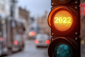A city crossing with a semaphore. Orange light with text 2022 in semaphore. Symbolic New Year...