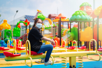 Asian teenage girl wearing a black shirt Happy playing in the playground on a clear day.