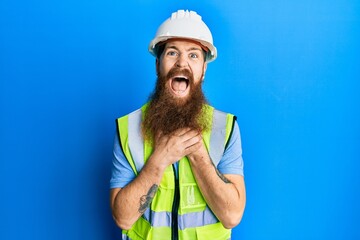 Redhead man with long beard wearing safety helmet and reflective jacket shouting and suffocate because painful strangle. health problem. asphyxiate and suicide concept.