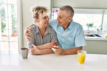 Obraz premium Senior caucasian couple smiling happy having breakfast at the kitchen.