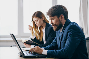 managers sitting at a desk with a laptop communication finance professionals