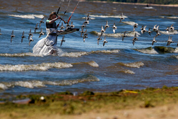 Kiter girl in long skirt  returns to shore after riding a kite