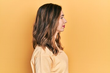 Young hispanic girl wearing casual clothes looking to side, relax profile pose with natural face with confident smile.