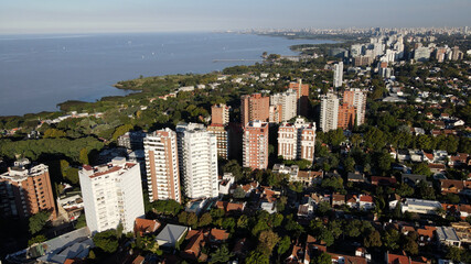 Aerial view of group of towers front to river surrounded with trees