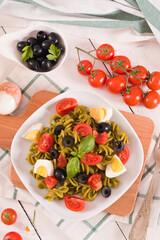 Fusilli pasta with cherry tomatoes, eggs and black olives.