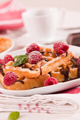 Waffles with raspberries and chocolate cream.