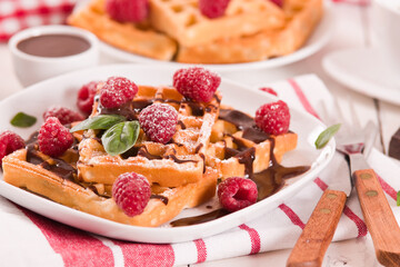 Waffles with raspberries and chocolate cream.