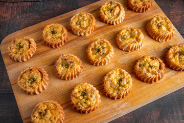 Muffins with vegetables and cheese on wooden board. Fresh homemade cakes for a healthy diet. Preparation of seasonal fall food.