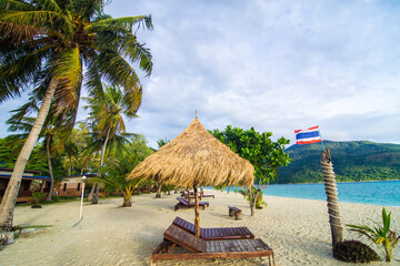 Wooden beach bench on white sand beach with coconut palm tree summer vacation
