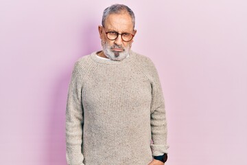 Handsome senior man with beard wearing casual sweater and glasses skeptic and nervous, frowning upset because of problem. negative person.