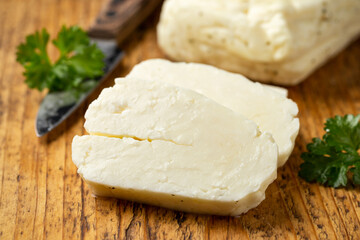 Sliced halloumi cheese with mint on wooden board