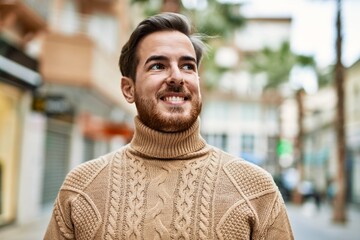 Young caucasian man smiling happy standing at the city.