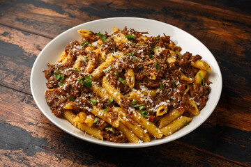 Pasta alla Genovese on a white bowl with parmesan cheese. Traditional neapolitan food.