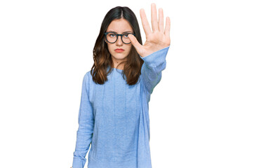 Young beautiful woman wearing casual clothes and glasses doing stop sing with palm of the hand....
