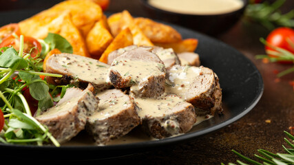 Roast Pork Tenderloin in mustard gravy with vegetables and potato wedges