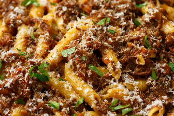 Pasta alla Genovese on a white bowl with parmesan cheese. Traditional neapolitan food.