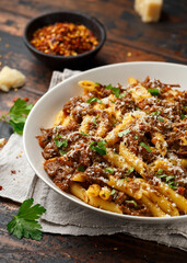Pasta alla Genovese on a white bowl with parmesan cheese. Traditional neapolitan food.