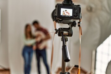 Professional camera taking photo of beautiful couple with dog at photography studio.