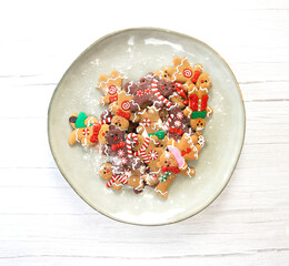 Christmas cookies,gingerbread man cookies with powdered sugar on natural plate, white wooden background texture,homemade top view
