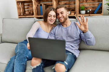 Young caucasian couple having video call using laptop at home.