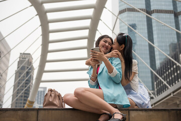 Young lesbian Asian couple kiss in city