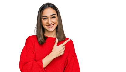 Beautiful brunette woman wearing casual winter sweater cheerful with a smile on face pointing with hand and finger up to the side with happy and natural expression