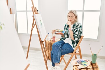 Young artist woman painting on canvas at art studio feeling unwell and coughing as symptom for cold or bronchitis. health care concept.