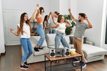 Group of young friends smiling happy and dancing at home.