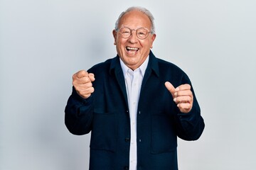 Senior man with grey hair wearing casual style and glasses very happy and excited doing winner gesture with arms raised, smiling and screaming for success. celebration concept.