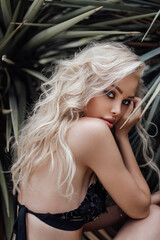 Fototapeta na wymiar beautiful woman with blond hair in elegant bikini posing in the tropic garden