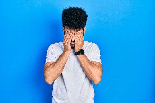 Young arab man with beard wearing casual white t shirt rubbing eyes for fatigue and headache, sleepy and tired expression. vision problem