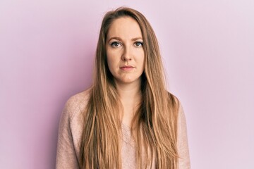Fototapeta premium Young blonde woman wearing casual sweater with serious expression on face. simple and natural looking at the camera.