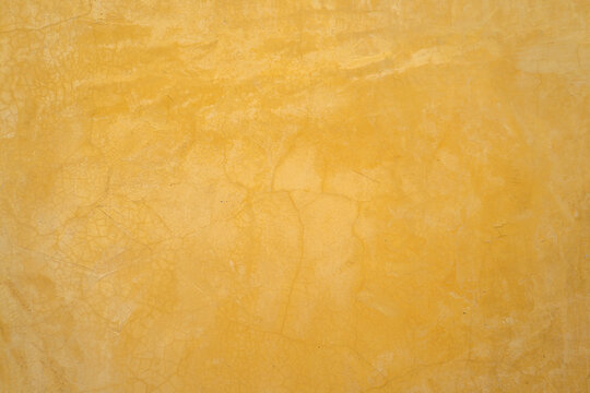 Pastel Yellow Mustard Cement Wall With Plaster And Cracked Pattern For Loft Style. Background And Texture Photo.