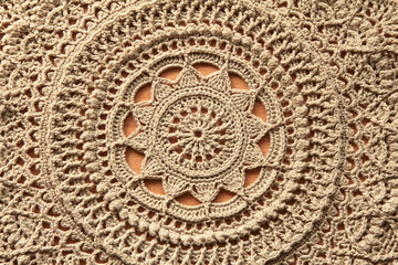 Fototapeta na wymiar Beautiful closeup beige crochet doily on wooden background