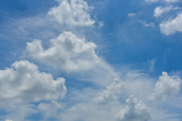 Beautiful cumulus clouds against the blue daytime sky.