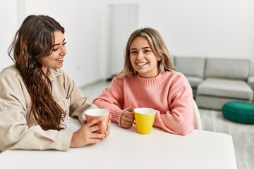 Young beautiful couple smiling happy drinking coffee at home.