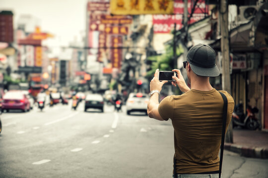 Man taking photo of city on smartphone