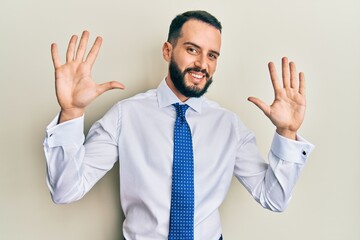 Young man with beard wearing business tie showing and pointing up with fingers number ten while smiling confident and happy.