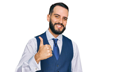 Young man with beard wearing business vest doing happy thumbs up gesture with hand. approving expression looking at the camera showing success.