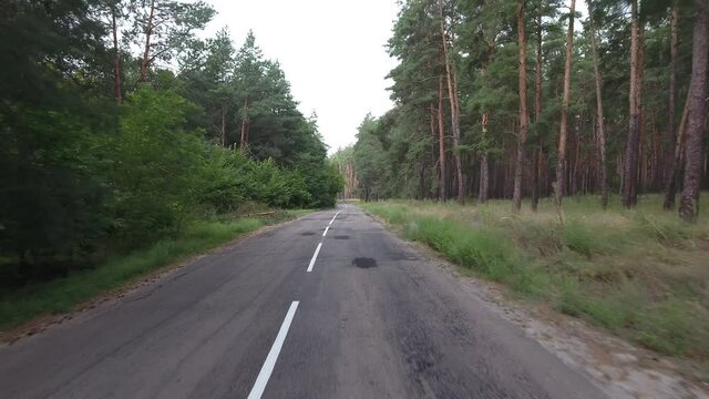 Flight and takeoff over an old road in a pine forest
