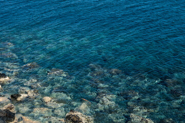 Naklejka na ściany i meble Sea stones on beach under water. Nature background.