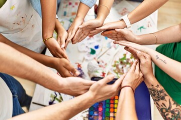 Group of people with hands together art studio.