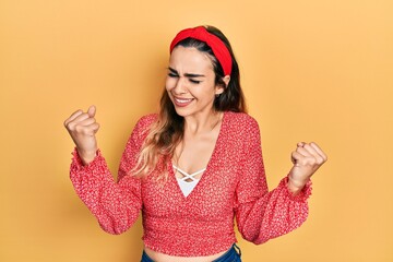 Young hispanic girl wearing casual clothes very happy and excited doing winner gesture with arms raised, smiling and screaming for success. celebration concept.