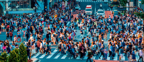 People and traffic cross the famous scramble intersection in Shibuya, Tokyo, Japan