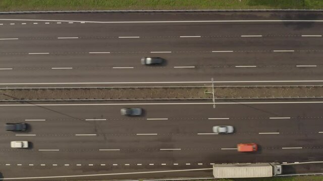 Boryspil highway near Kiev from a bird's eye view. Chausse passes through a dense green forest. The city of Kiev is visible ahead.