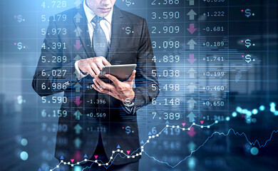 Businessman in formal suit is holding tablet and touching it