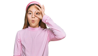 Fototapeta na wymiar Beautiful brunette little girl wearing casual turtleneck sweater doing ok gesture shocked with surprised face, eye looking through fingers. unbelieving expression.