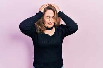 Middle age caucasian woman wearing casual clothes suffering from headache desperate and stressed because pain and migraine. hands on head.